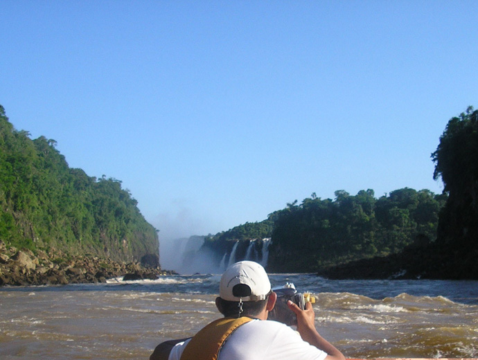 Макуко сафари сред водите на река Игуасу. Нагоре по течението се вижда и главната част от водопада.